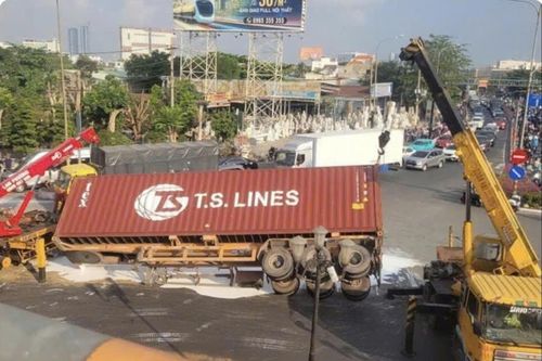 Xe container chở sơn lật giữa vòng xoay ở TPHCM, sơn trắng tràn khắp mặt đường