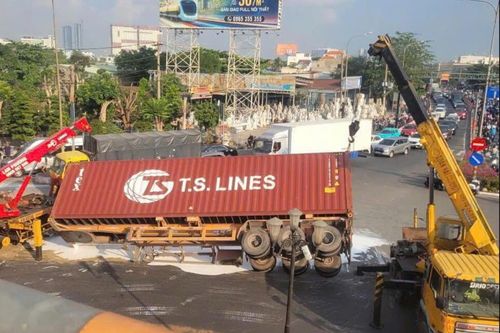 Xe container lật giữa vòng xoay ở TP.HCM, sơn trắng tràn mặt đường