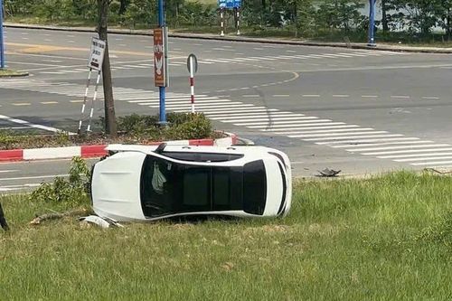 TP.HCM: Mercedes băng qua ngã tư, tông gãy cây xanh rồi lật nhào lên bãi cỏ ven đường
