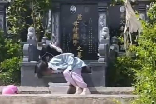 Cảnh bé gái nằm bên mộ ông bà khiến dân mạng xúc động