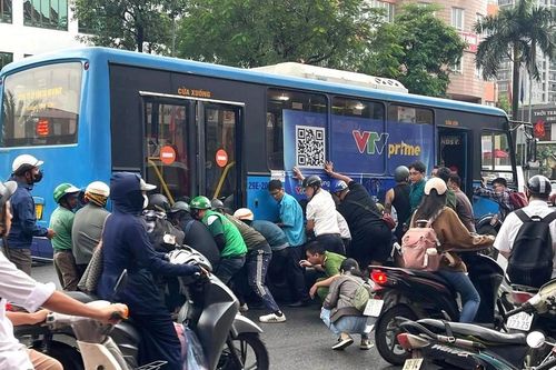 Hà Nội: Người dân hợp sức nâng xe buýt cứu nữ tài xế xe máy mắc kẹt sau va chạm