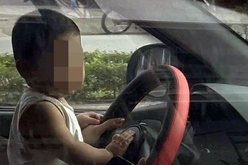 CSGT làm việc với nữ tài xế để trẻ nhỏ ngồi trước vô lăng khi đang di chuyển