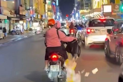 Người phụ nữ rải giấy nghi vàng mã giữa đường ở TP.HCM