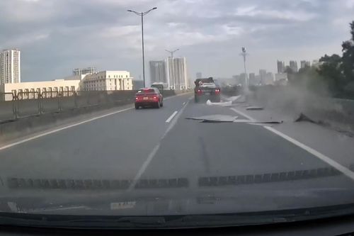 Loạt tấm tôn bay từ xe đầu kéo xuống đường, ô tô đi sau thoát nạn trong gang tấc