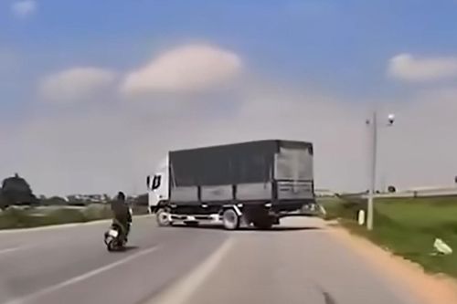 Thanh niên chạy xe máy trượt ngã vào gầm ô tô tải đang quay đầu