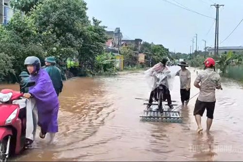 Lực lượng chức năng hỗ trợ người dân qua điểm ngập trên Quốc lộ 279