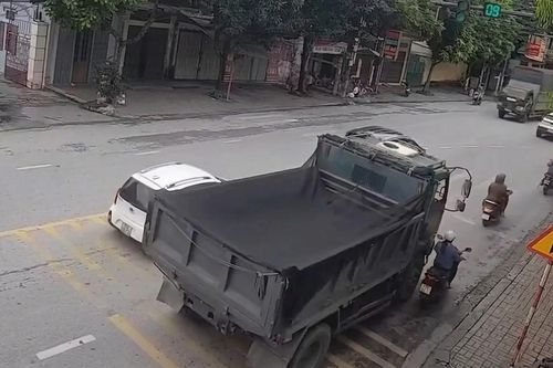 Xe ben vượt phải ở giây cuối đèn xanh, ép xe máy vào lề rồi cán qua