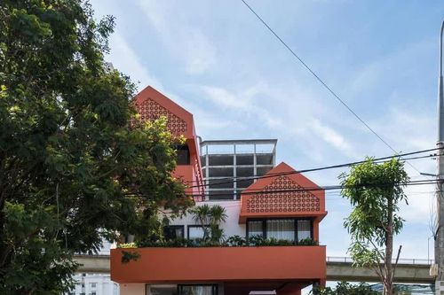 Ngôi nhà có mặt tiền tông màu đỏ đất nổi bật giữa khu phố