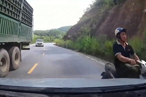 Xe máy vượt ẩu ở khúc cua, suýt đối đầu ô tô