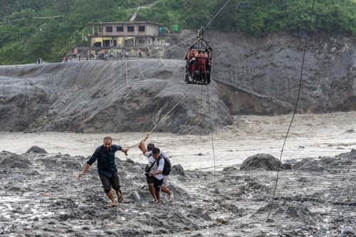 Những người bị mắc kẹt ở vùng lũ Nepal vượt sông Trishuli bằng dây cáp trượt