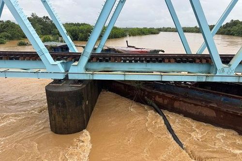 Lũ cuốn sà lan mắc kẹt dưới cầu đường sắt Bắc - Nam ở Quảng Trị
