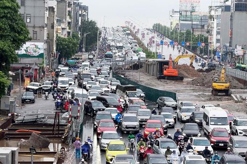 Người Hà Nội đội mưa lớn đi làm, 'chôn chân' trên những tuyến đường ùn tắc