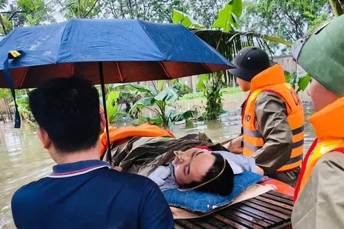 Cảnh sát dùng xuồng vượt khu vực ngập đưa người bị liệt đi cấp cứu