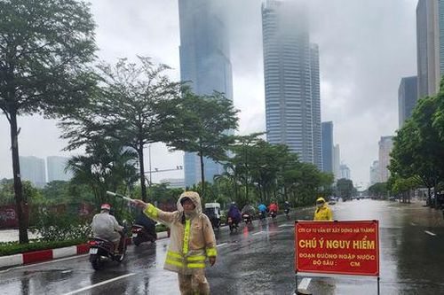 Cảnh sát giao thông Hà Nội phân luồng, hướng dẫn người dân di chuyển trong mưa