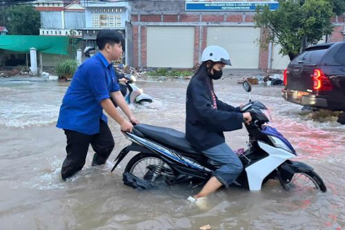 Người đi xe ngã nhào xuống dòng nước đục ngầu vì triều cường