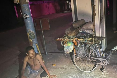 Người đàn ông ngồi bên chiếc xe đạp cũ chở nhiều phế liệu giữa đêm và câu chuyện ấm lòng phía sau