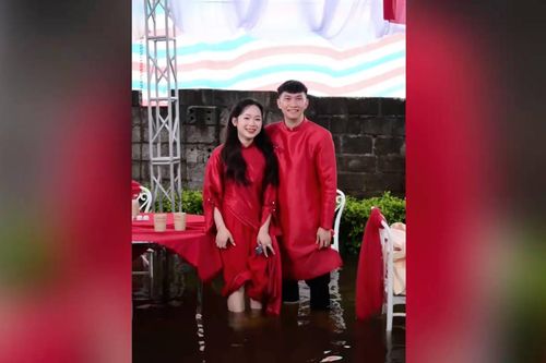 Cô dâu chú rể cùng quan khách xắn quần vì mưa ngập rạp đám hỏi