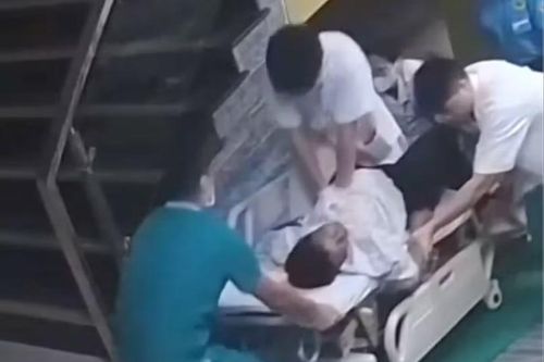 Bác sĩ trẻ ngồi trên băng ca, ép tim cứu bệnh nhân