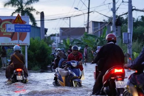 Triều cường ở TPHCM leo đỉnh, người dân bì bõm lội nước chiều cuối tuần
