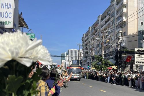 Người dân cầm hoa trắng tiễn đưa Anh hùng liệt sĩ ở công viên Lê Thị Riêng về nơi an nghỉ