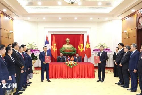 Thường trực Ban Bí thư Trần Cẩm Tú và Thường trực Ban Bí thư Trung ương Đảng Nhân dân Cách mạng Lào chứng kiến Lễ trao văn kiện hợp tác giữa hai văn phòng Trung ương