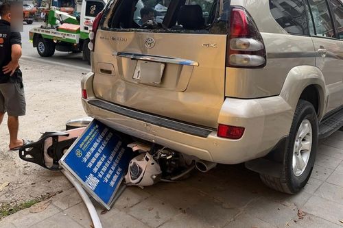 Ô tô Prado lùi trên đường Hà Nội, cuốn xe máy chở 2 phụ nữ vào gầm