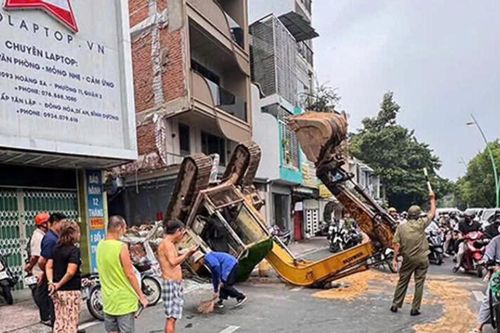 Xe múc 5 tấn lật ngửa ở TP.HCM