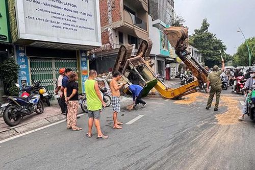 TPHCM: Xe múc đang tháo dỡ nhà bất ngờ lật ngửa giữa đường