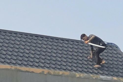 Cảnh sát vây bắt hai người cầm hung khí cố thủ trên mái nhà ở Thanh Hóa