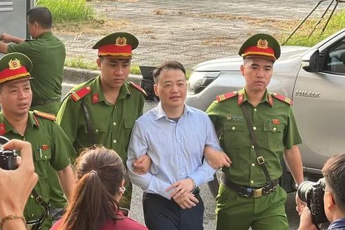 Shark Bình nở nụ cười khi được dẫn giải đến toà