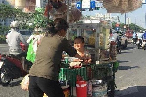 Em bé Sài Gòn mỉm cười hạnh phúc bên gánh hàng rong của mẹ