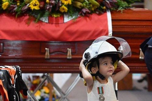 Cô bé đội chiếc mũ cứu hỏa và hôn tạm biệt người cha hy sinh trong trận hỏa hoạn