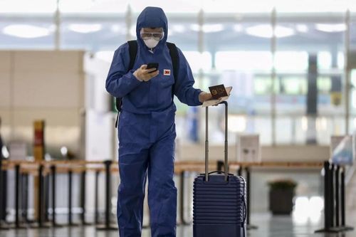 Du khách mặc đồ bảo hộ, sân bay Hong Kong hoang vắng vì dịch Covid-19