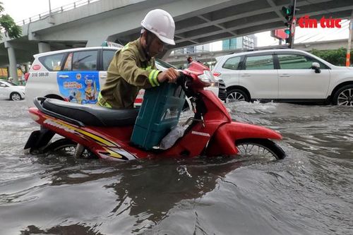 TP Hồ Chí Minh mưa lớn, người dân 'bì bõm' nước về nhà