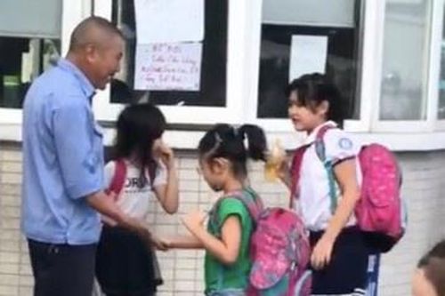 Bác bảo vệ đập tay, chào hỏi học sinh trước cổng trường mỗi sáng