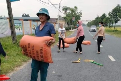 Mưa giông bất ngờ, giáo viên 'xắn tay' giúp bà con gom lúa 'chạy mưa'