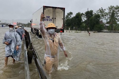Cảnh sát giao thông dầm mình trong mưa lũ đón người dân về quê