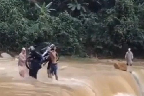Xôn xao clip 4 người đàn ông khiêng chiếc xe máy vượt dòng lũ dữ chảy xiết