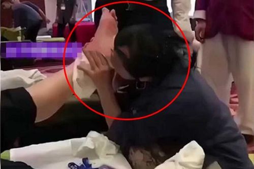 Nhân viên massage dùng răng miệng để...xoa bóp chân cho khách