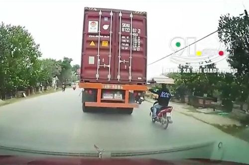 Clip: Ngán ngẩm thanh niên đầu trần, chạy xe máy liều lĩnh đu bám vào đuôi container trên đường