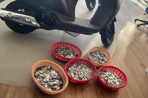 Ông chủ tiệm tạp hóa mang bao tải tiền đi mua xe máy