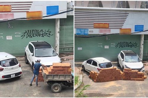 Hai ô tô đỗ trước cửa nhà, người đàn ông xếp hai hàng gạch chặn gây tranh cãi