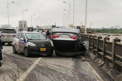 Ôtô Honda Civic lật ngửa trên cầu Vĩnh Tuy sau va chạm với xe taxi