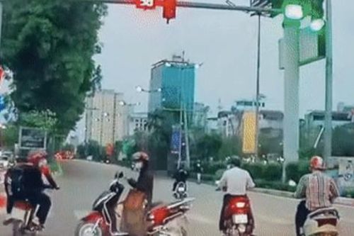 Ngán ngẩm người phụ nữ dừng xe máy giữa ngã tư bấm điện thoại