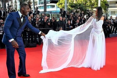 Người đàn ông quyến rũ nhất thế giới chỉnh váy cho vợ ở Cannes