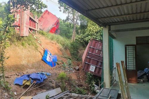 Thùng xe container lật đè sập tường nhà dân