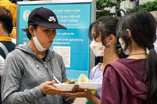 Người TP.HCM 'đội nắng' vừa ăn cơm, vừa xếp hàng chờ làm hộ chiếu