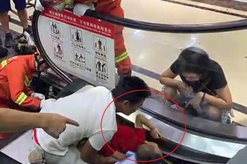 Bé trai bị mắc kẹt khi đi thang cuốn ở Trung Quốc