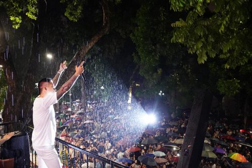 Tuấn Hưng đội mưa hát từ ban công nhà, hát xong tặng áo cho khán giả