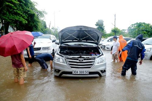 Hà Nội: Người dân kê gạch chống ngập nước cho ô tô sau cơn mưa lớn